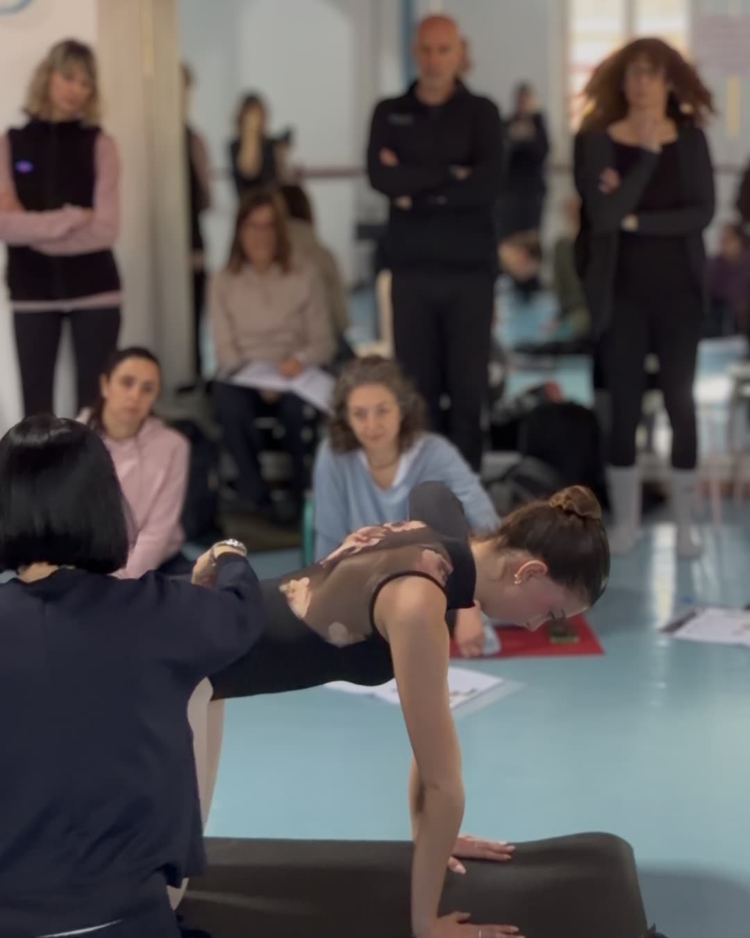 Chiara Sicuri guida una danzatrice durante un esercizio, i corsisti osservano